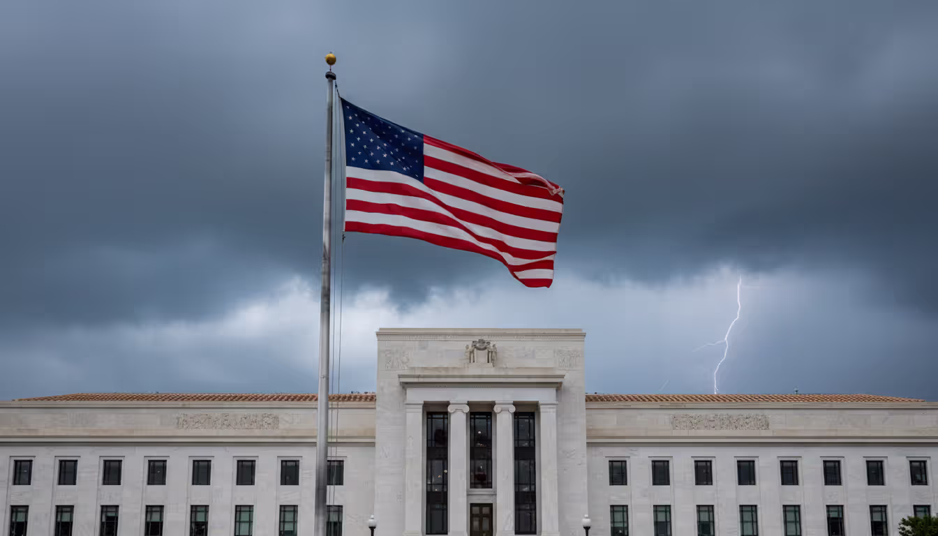 Federal Reserve Eccles Building facade in Washington DC under dramatic stormy sky with American flag in the foreground
