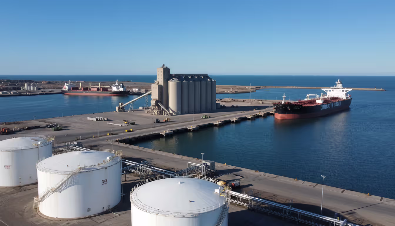 Industrial port with oil storage tanks tanker ship and grain elevators illustrating diverse physical commodity operations